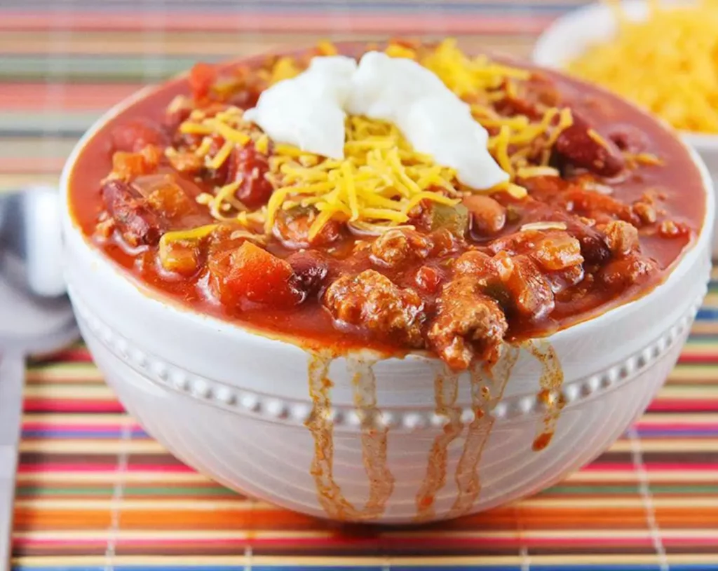 Chili in a white bowl with good amount of toppings