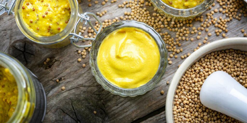 image representing a mustard dip along with mustard seeds